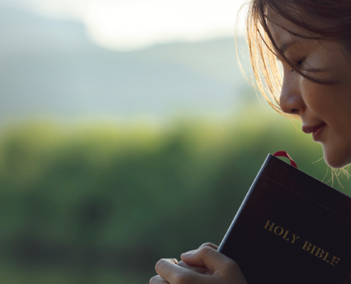 woman holding on to Holy Bible