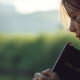woman holding on to Holy Bible