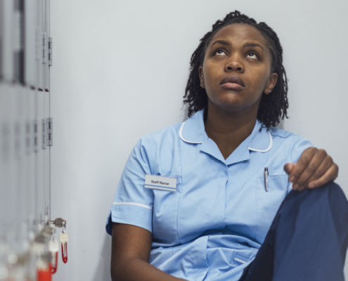 nurse looking somber whilst looking up to sky