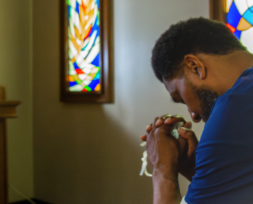 weary healthcarer praying in church